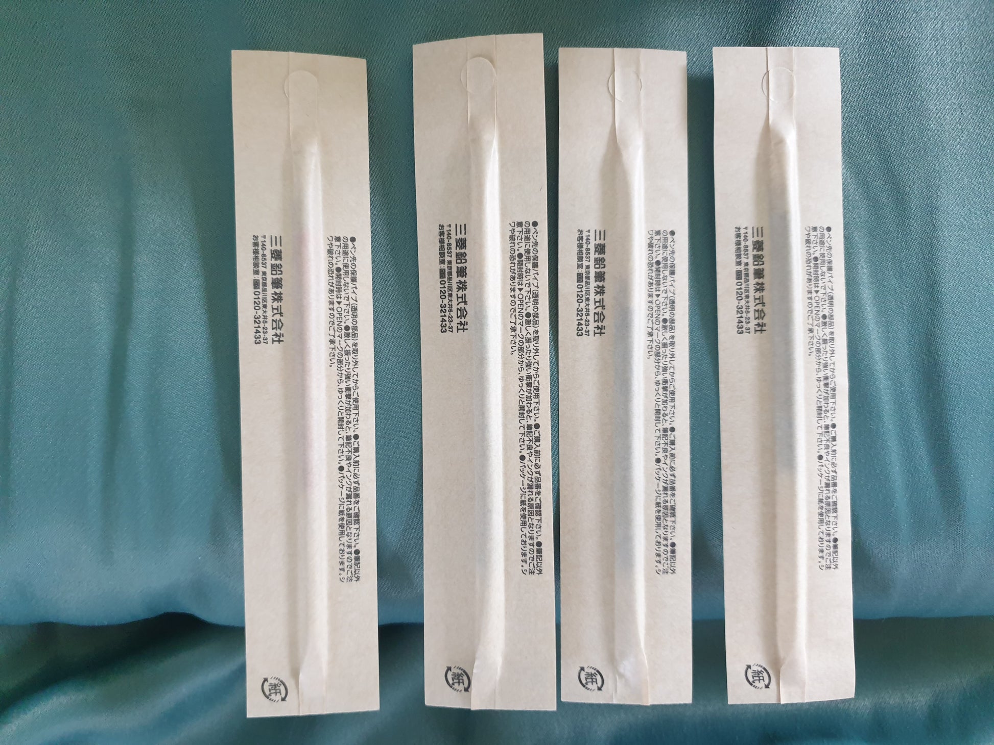 Kugelschreibermine Papierverpackung hinten, vor Stoffhintergrund