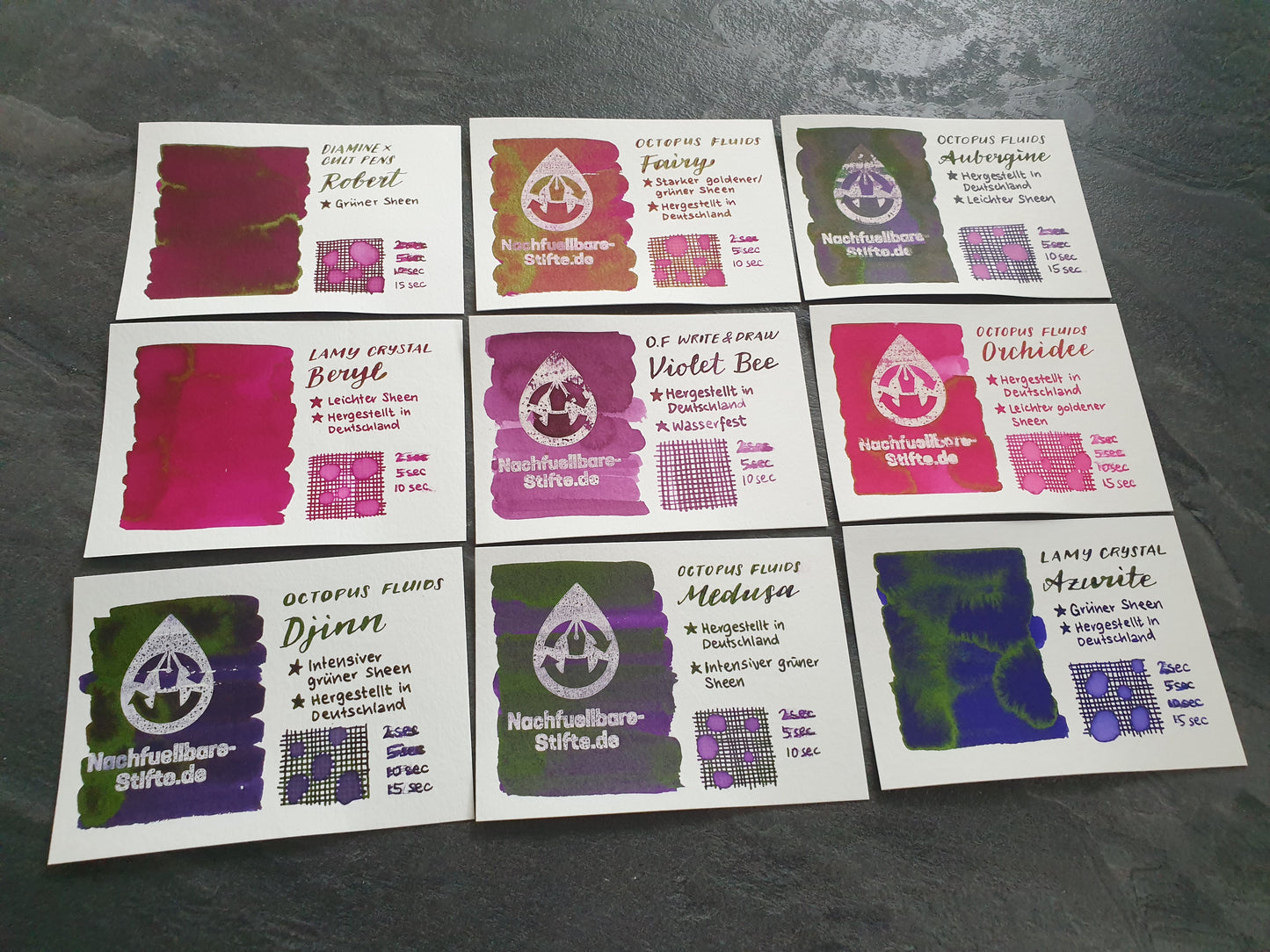 Vergleichsfoto mit Tintenswatches der Füllertinten: Diamine Robert, Octopus Fluids Fairy, Octopus Fluids Aubergine, Lamy Crystal Beryl, Octopus Fluids Write & Draw Violet Bee, Octopus Fluids Orchidee, Octopus Fluids Djinn, Octopus Fluids Medusa, Lamy Crystal Azurite