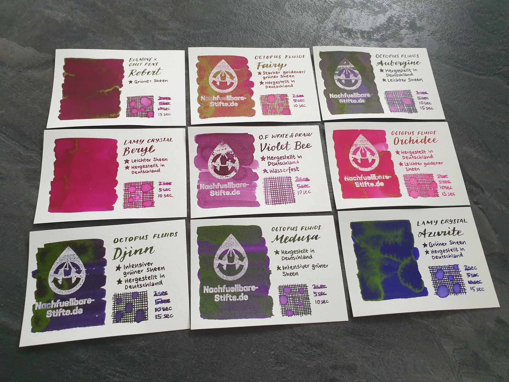 Vergleichsfoto mit Tintenswatches der Füllertinten: Diamine Robert, Octopus Fluids Fairy, Octopus Fluids Aubergine, Lamy Crystal Beryl, Octopus Fluids Write & Draw Violet Bee, Octopus Fluids Orchidee, Octopus Fluids Djinn, Octopus Fluids Medusa, Lamy Crystal Azurite