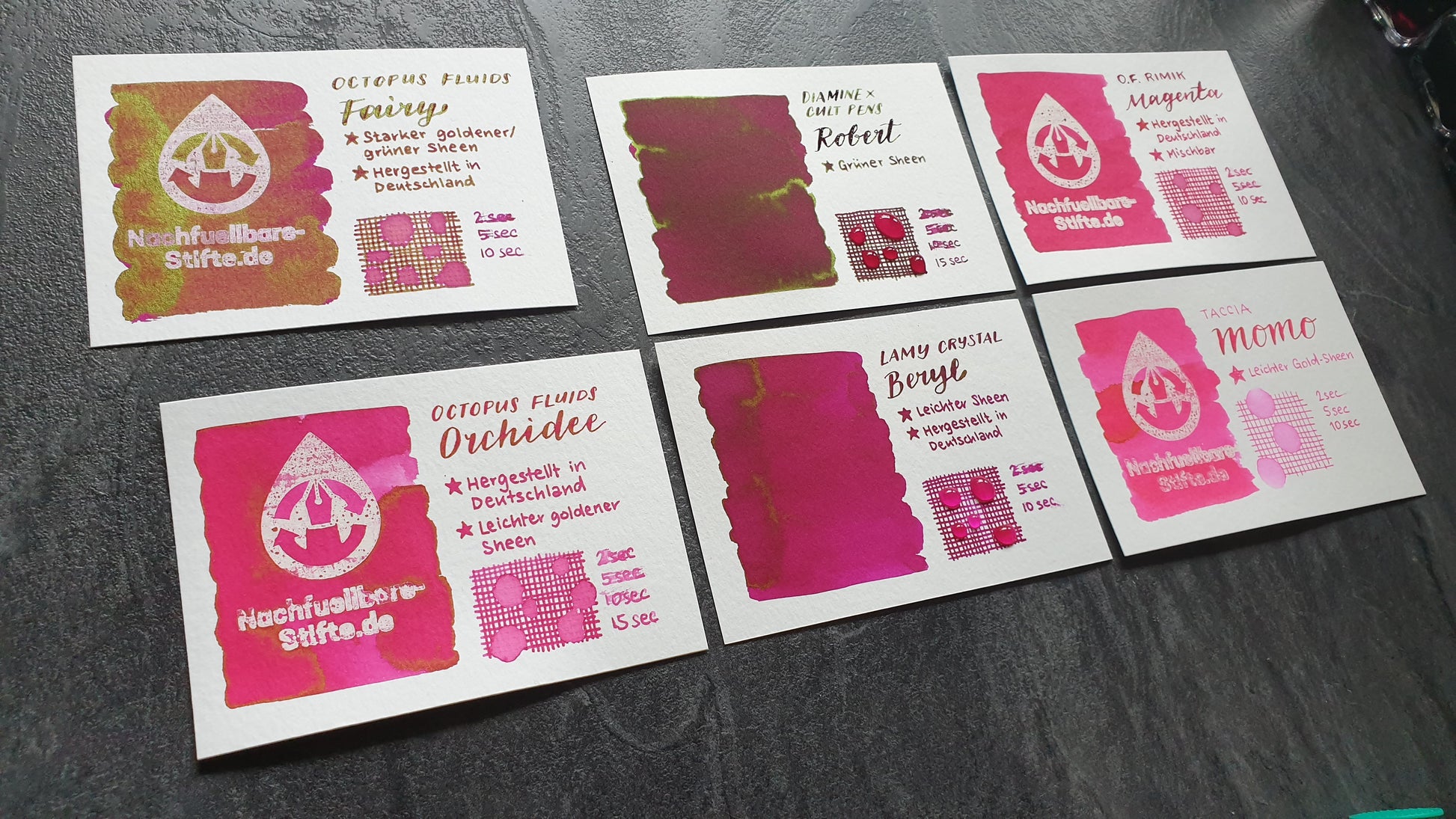 Vergleichsfoto mit Tintenswatches der Füllertinten: Octopus Fluids Fairy, Diamine Robert, Octopus Fluids Rimik Magenta, Octopus Fluids Orchidee, Lamy Crystal Beryl, Taccia Momo